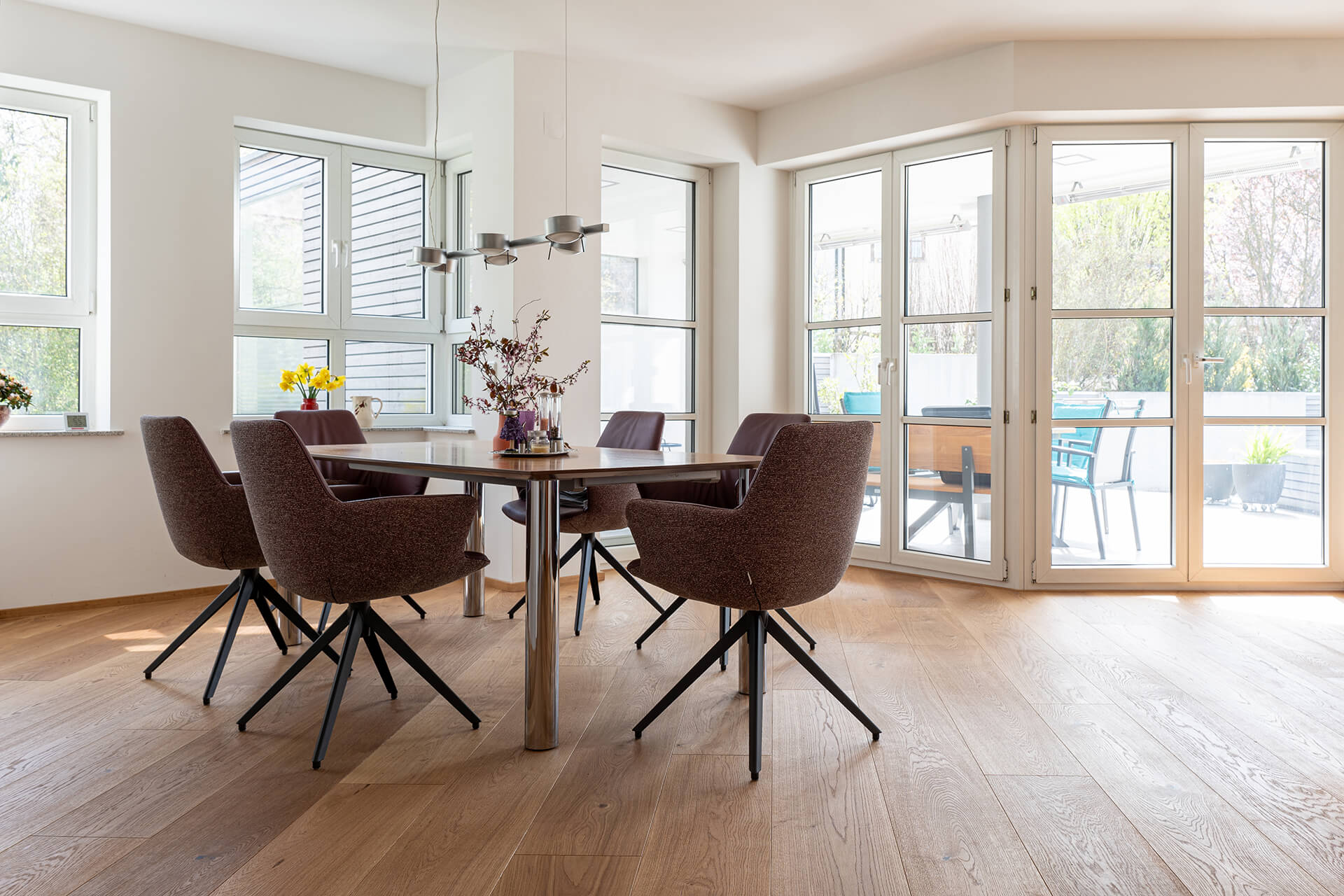 Schöne breite andhausdiele in modernem Wohnzimmer mit Esstisch und Stühlen