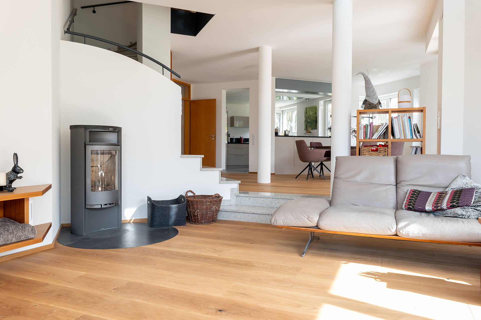 gemütliches Wohnzimmer mit breiter Landhausdiele, Kachelofen und Sofa