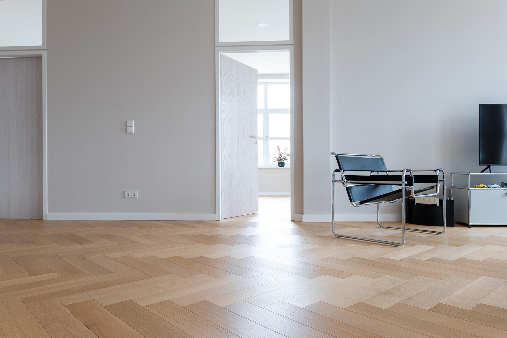 Comfort Tabis XL als Fischgrat verlegt mit ruhiger Sortierung in heller Wohnung mit Stuhl