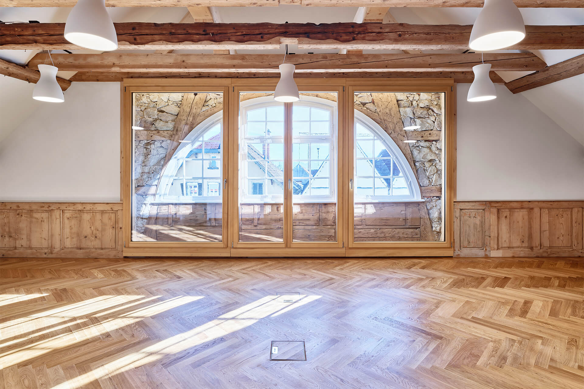 parkettboden-fischgrat-bürgerbüro-hofapotheke-hechingen-3 Massivholz Stabparkett im Fischgrat-Muster unter dem historischen Rundbogenfenster der Hofapotheke Hechingen