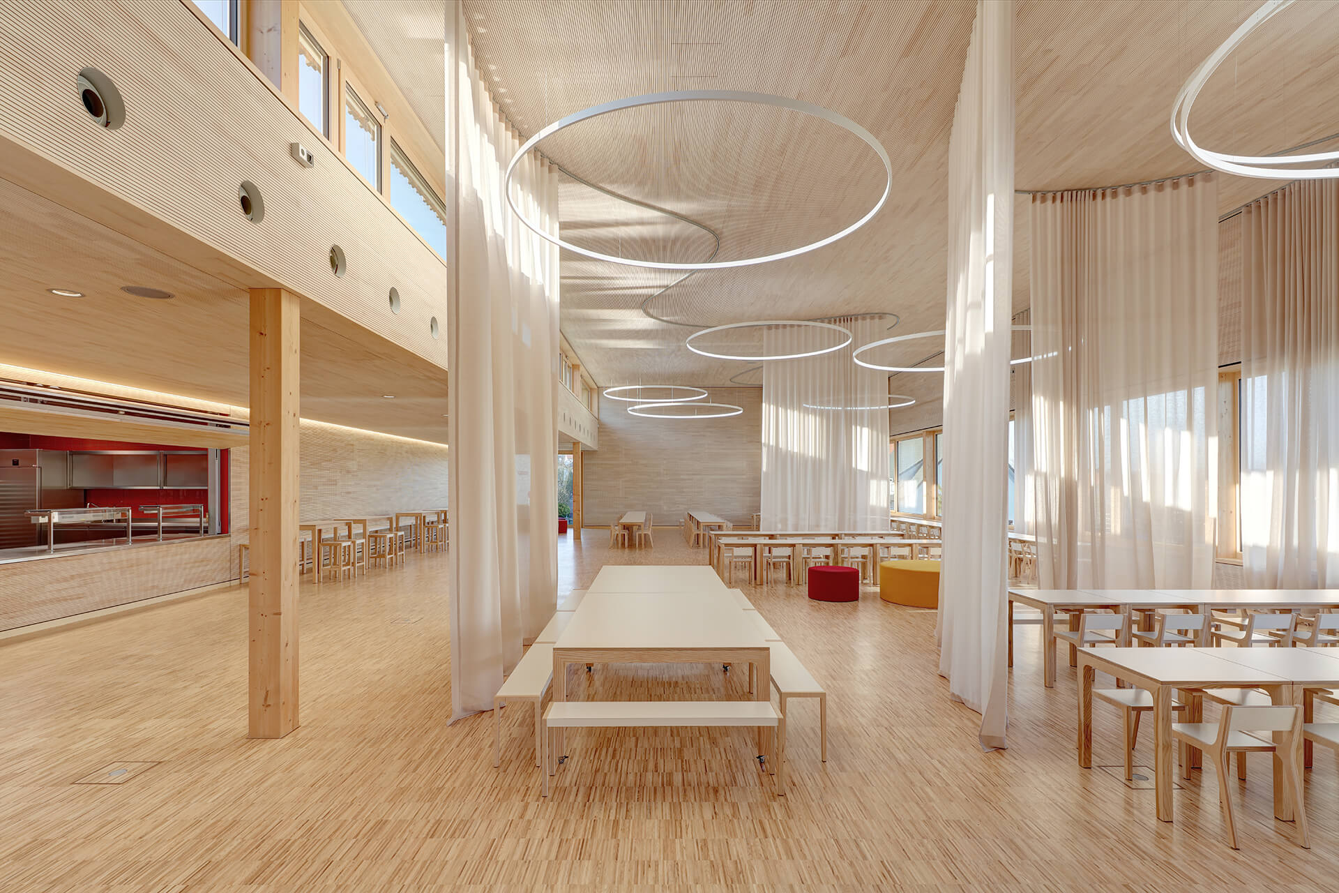 syrlin-grunschule-ulm-industrieparkett-esche-2 Mensa der Syrlin Grundschule Ulm mit 600 m² Industrieparkett Esche versiegelt, Holzbau und kreisförmigen Pendelleuchten