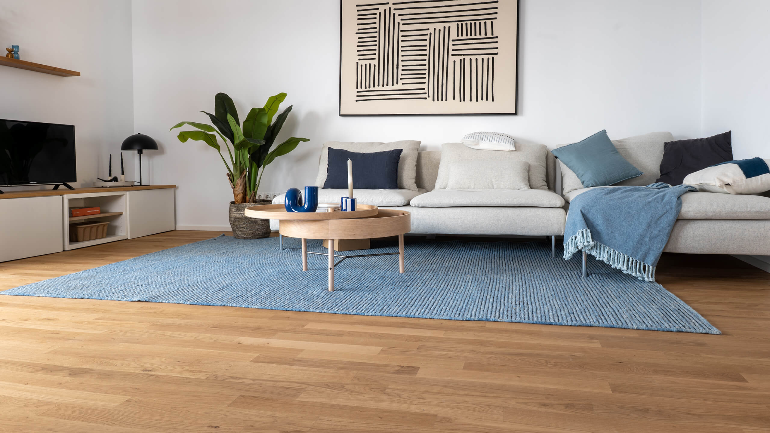 comfort-tabis-eiche-classic-geoelt-eppelheim-6 Parkettboden aus Eichenholz in modernem Wohnzimmer einer Musterwohnung in Eppelheim mit heller Couch, Beistelltisch